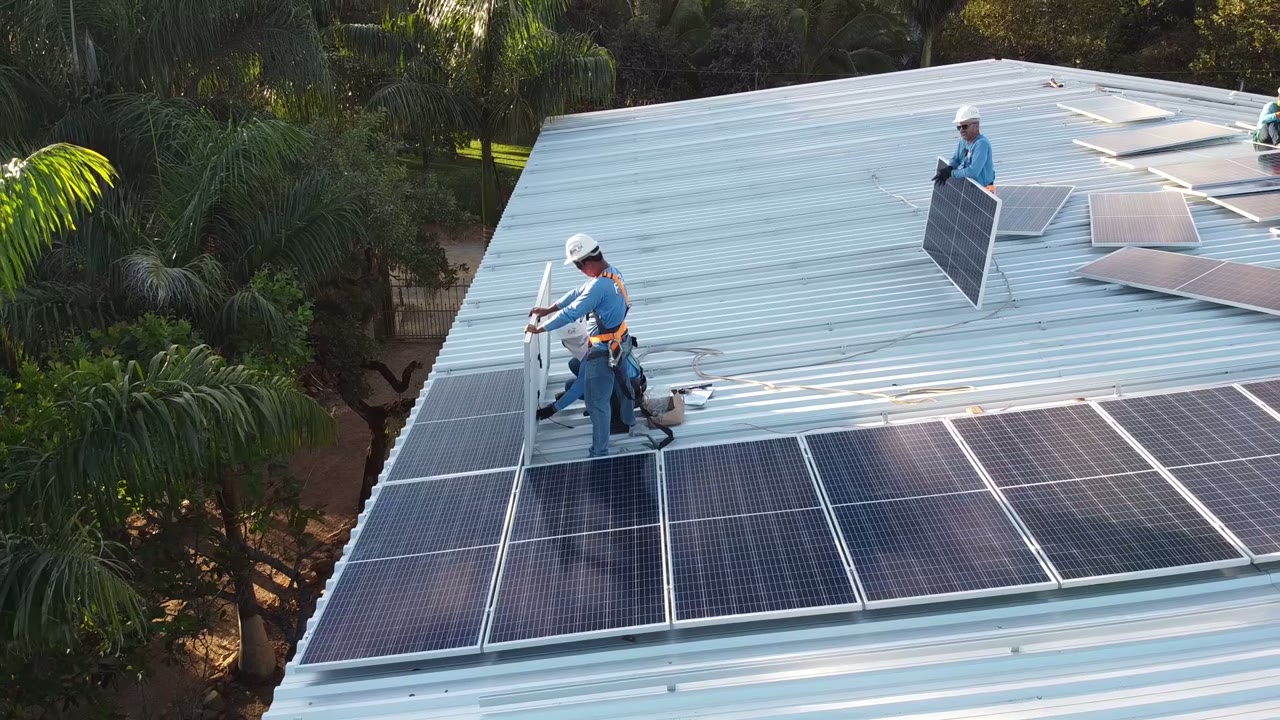 Técnicos da Fysol trabalhando na instalação de módulos fotovoltaicos em telhado